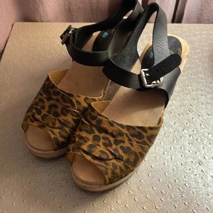 Wooden sandal clogs in leopard print with black leather buckle detail.